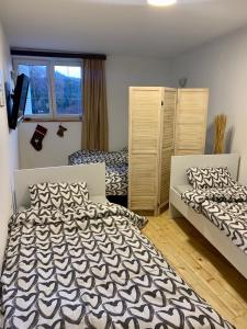 a bedroom with two beds and a window at Ski-in & Ski-out, Apartman Filip - 30m from GONDOLA Brzeće in Kopaonik