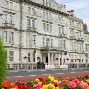 a large white building with flowers in front of it at Hotel Prince Regent in Weymouth