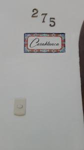 un panneau sur un mur avec une horloge. dans l'établissement Casablanca 2, à Tacna
