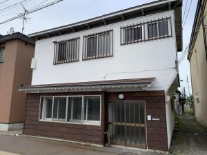 um edifício branco e castanho com garagem em kODATEL コダテル函館ウエストサイド em Hakodate