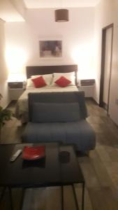 1 dormitorio con cama, sofá y mesa en OLASCOAGA DOS monoambiente en Mendoza