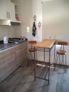 cocina con mesa de madera y 2 taburetes en OLASCOAGA DOS monoambiente en Mendoza