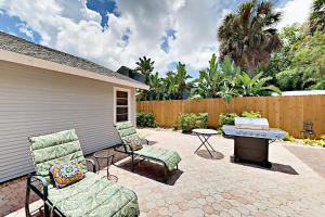 a patio with two chairs and a table and a fence at Doplin Paradise in Bradenton