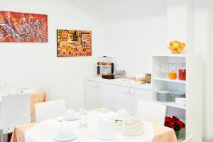 biała jadalnia ze stołem i krzesłami w obiekcie Le Vette Room&Breakfast w mieście Rovereto