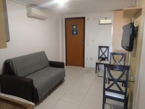 salon z kanapą i telewizorem w obiekcie Manaíra Palace 419 w mieście João Pessoa
