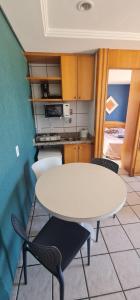 una cocina con mesa y sillas blancas en CLASSIC FLAT RESIDENCE Beira Mar- 1004, en Fortaleza
