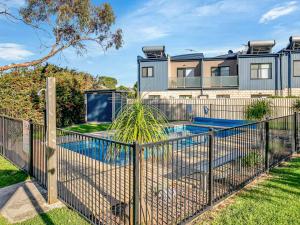 a fence with a pool in front of a house at Starfish Sands in Cowes