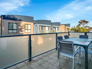 a patio with a table and chairs on a balcony at Starfish Sands in Cowes