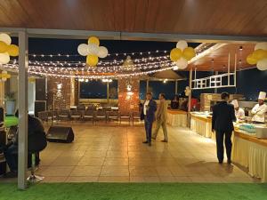 a group of people walking around a restaurant with balloons at Hotel BMD The Grand in Bhilwara