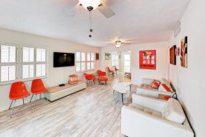 a living room with a couch and red chairs at Endless Summer in Clearwater Beach