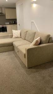 ein braunes Sofa im Wohnzimmer mit Küche in der Unterkunft DealHouse F7- Apartments in Huddersfield