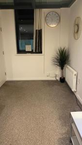 ein Zimmer mit einem Fenster und einer Uhr an der Wand in der Unterkunft DealHouse F7- Apartments in Huddersfield