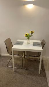 ein weißer Tisch mit einer Vase Blumen drauf in der Unterkunft DealHouse F7- Apartments in Huddersfield