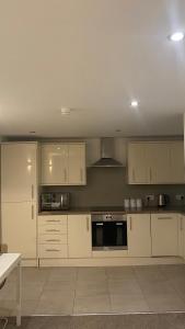 a kitchen with white cabinets and a stove top oven at DealHouse F7- Apartments in Huddersfield