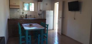 een keuken met een tafel en stoelen en een koelkast bij Casa dos dormitorios en excelente ubicación in San Rafael
