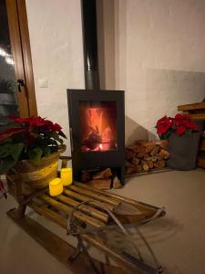 a fireplace in a living room with a bench and flowers at Encantadora casa rural con piscina privada in El Bosque