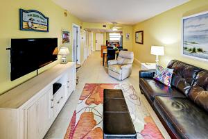 a living room with a couch and a flat screen tv at Vistas On The Gulf Unit 408 in St. Pete Beach