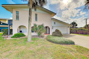 a house with a palm tree in front of it at Seaside Cottage in Saint Augustine