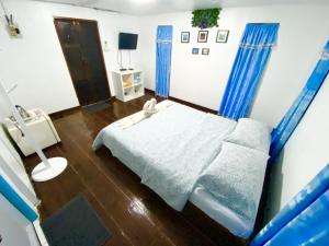 una camera ospedaliera con un letto e tende blu di Jamsai Resort a Phu Khieo
