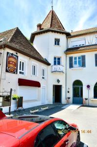 a red car parked in front of a building at Studio, Bord de Lac, 4 Pers. in Paladru