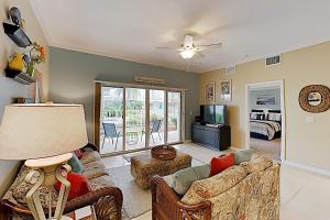 a living room with two couches and a television at Villas Ocean Gate II Condo Unit 105 in Saint Augustine