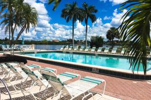 a swimming pool with lounge chairs and a body of water at The Palm Bay Club Unit 311 in Siesta Key