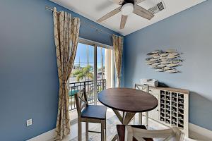 a dining room with a table and chairs and a balcony at Emerald Dreams in St Pete Beach
