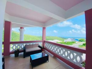 a balcony with a couch and a view of the ocean at Sea-Renity in Philipsburg