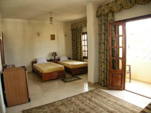 a hotel room with two beds and a door at Luxor Hotel Hurghada in Hurghada +59 photos