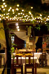 una sala da pranzo con tavoli, sedie e luci di Perezoso Hostel a Rurrenabaque