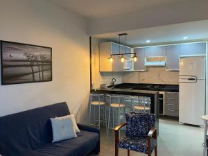 a living room with a couch and a kitchen at APARTAMENTO PORTO REAL RESORT VISTA ESPETACULAR in Mangaratiba