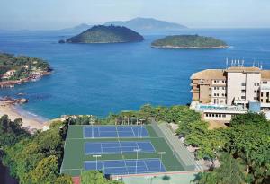 una vista aerea su un campo da tennis vicino all'oceano di APARTAMENTO PORTO REAL RESORT VISTA ESPETACULAR a Mangaratiba