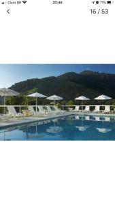 a large swimming pool with umbrellas and chairs at APARTAMENTO PORTO REAL RESORT VISTA ESPETACULAR in Mangaratiba