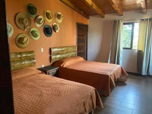 a room with two beds and plates on the wall at Cabaña La Lomita in Mazamitla