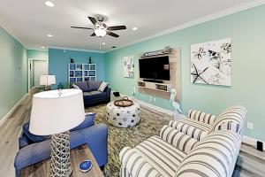 a living room with two couches and a tv at Grand View #103 in Fort Myers