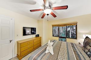 Schlafzimmer mit Deckenventilator und TV in der Unterkunft Holiday Island 44D in Tierra Verde