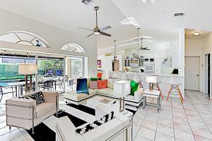 a living room with white furniture and a kitchen at Chic Beach Haven in Marco Island