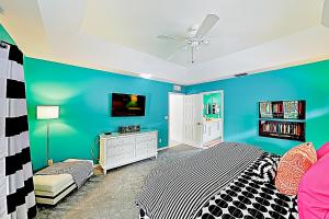 a blue bedroom with a bed and a tv at Chic Beach Haven in Marco Island