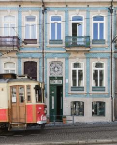 a trolley car parked in front of a building at Maison des Amis Porto in Porto