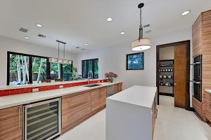 eine Küche mit Holzschränken und einer weißen Arbeitsplatte in der Unterkunft Wilton Manors Highlife in Fort Lauderdale