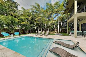 einen Pool mit Stühlen und ein Haus in der Unterkunft Wilton Manors Highlife in Fort Lauderdale