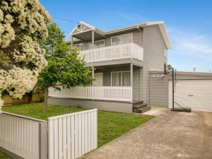 a large house with a white fence and a driveway at Lansell Retreat in Cowes