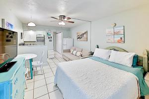 a bedroom with a large bed and a kitchen at Pass-A-Grille Beach Retreat Unit 8 in St. Pete Beach