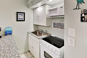 uma pequena cozinha com um lavatório e um micro-ondas em Pass-A-Grille Beach Retreat Unit 8 em St. Pete Beach