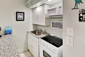 una piccola cucina con lavandino e forno a microonde di Pass-A-Grille Beach Retreat Unit 8 a St Pete Beach