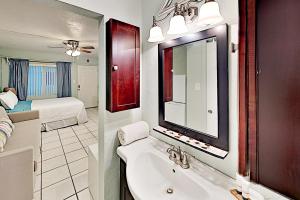 a bathroom with a sink and a mirror and a bed at Pass-A-Grille Beach Retreat Unit 8 in St Pete Beach