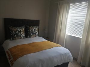 a bedroom with a large bed with a window at Ons Strandhuisie Mh18 in Pearly Beach in Pearly Beach