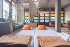 two large beds in a room with windows at RedDoorz near Kampung Gajah 2 in Bandung