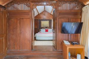 1 dormitorio con 1 cama y TV en una habitación en RedDoorz near Kampung Gajah 2, en Bandung