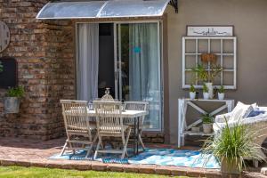 eine Terrasse mit einem Tisch und Stühlen auf einer Terrasse in der Unterkunft Ons Huisie - No Loadshedding in Beaufort West